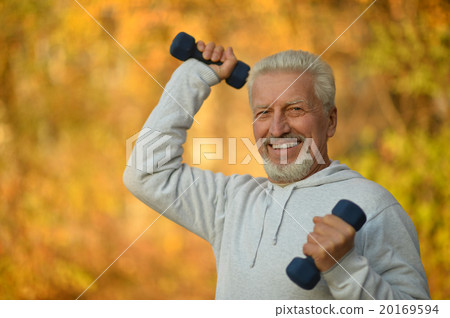 Elderly man exercising with dumbbells 20169594