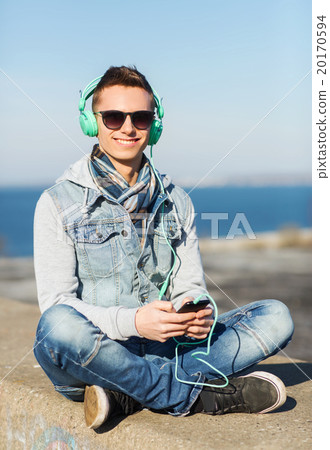 happy young man in headphones with smartphone happy young man in headphones with smartphone 20170594