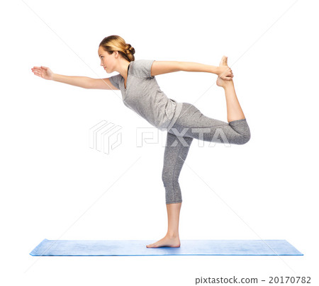 woman making yoga in lord of the dance pose on mat 20170782