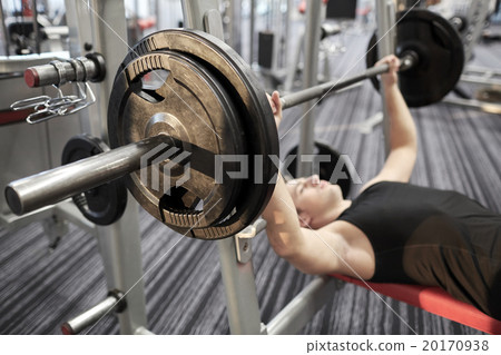 close up of man flexing biceps with barbell in gym 20170938