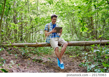 happy man with backpack and tablet pc in woods 20170963