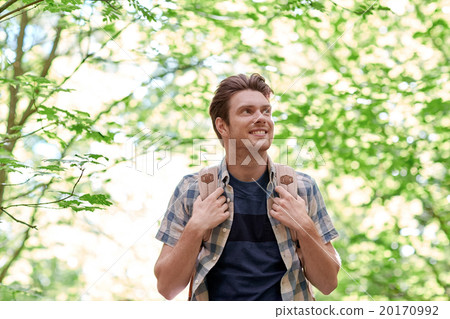 smiling young man with backpack hiking in woods 20170992