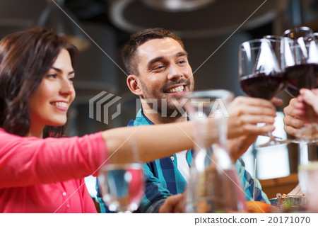 friends clinking glasses of wine at restaurant friends clinking glasses of wine at restaurant 20171070