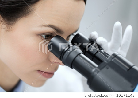 close up of scientist looking to microscope in lab 20171143