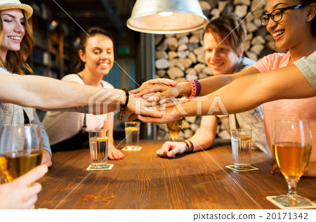 friends putting hands on top of each other at bar 20171342