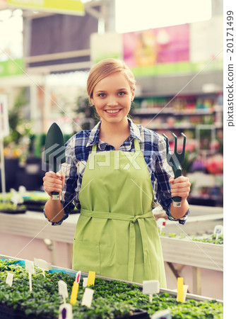 happy woman with gardening tools in greenhouse 20171499