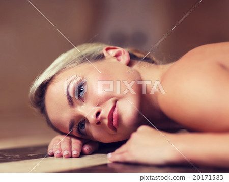 young woman lying on hammam table in turkish bath 20171583