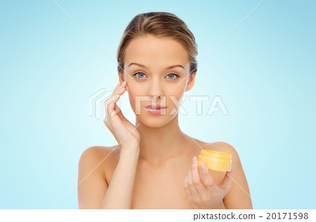 young woman applying cream to her face young woman applying cream to her face 20171598