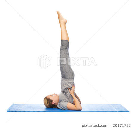 woman making yoga in shoulderstand pose on mat 20171732