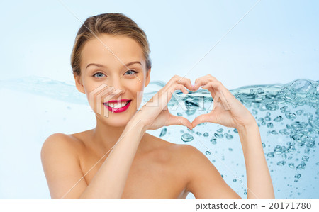 smiling young woman showing heart shape hand sign 20171780