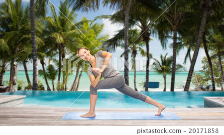 woman making yoga low angle lunge pose over beach 20171858
