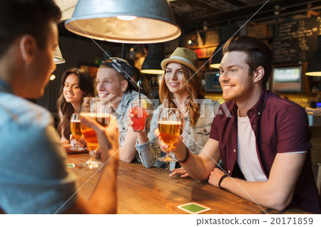 happy friends with drinks talking at bar or pub 20171859