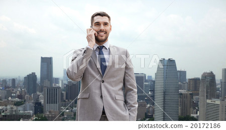 smiling businessman with smartphone in city smiling businessman with smartphone in city 20172186