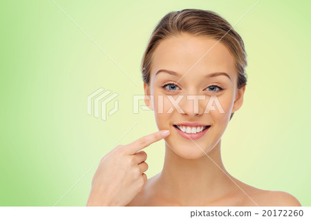 happy young woman pointing finger to her teeth happy young woman pointing finger to her teeth 20172260