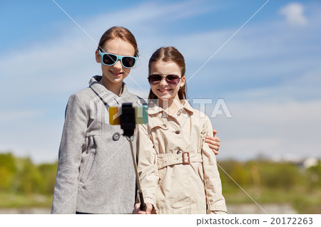 happy girls with smartphone selfie stick happy girls with smartphone selfie stick 20172263