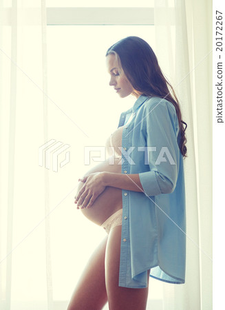 happy pregnant woman with big bare tummy at home happy pregnant woman with big bare tummy at home 20172267