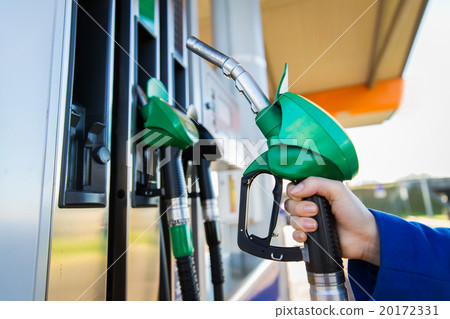 close up of hand holding hose at gas station close up of hand holding hose at gas station 20172331