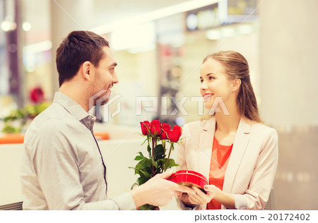 happy couple with present and flowers in mall happy couple with present and flowers in mall 20172402