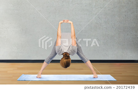woman making yoga in wide-legged forward bend pose 20172439