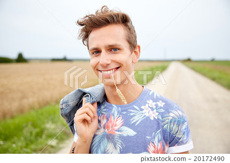 smiling young hippie man on country road 20172490