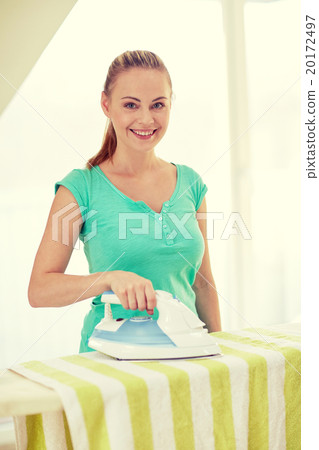 happy woman with iron and ironing board at home happy woman with iron and ironing board at home 20172497
