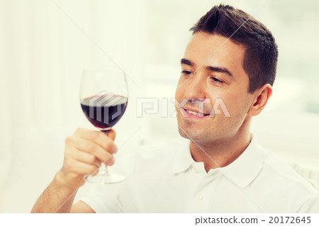 happy man drinking red wine from glass at home 20172645
