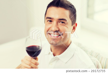 happy man drinking red wine from glass at home 20172735