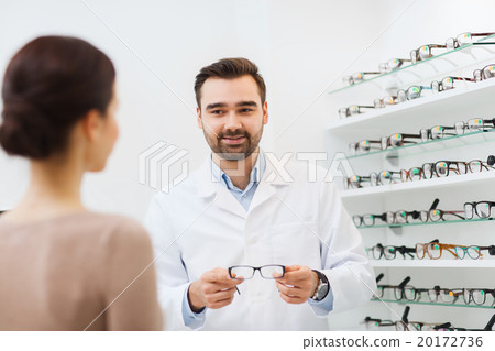 woman and optician showing glasses at optics store 20172736