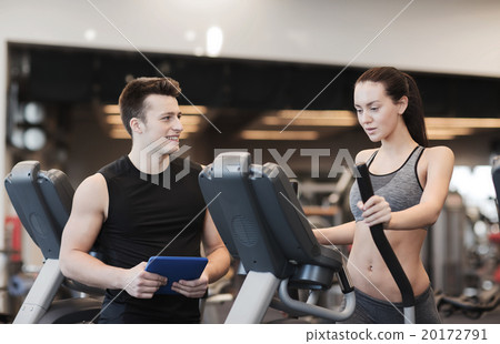 woman with trainer exercising on stepper in gym 20172791