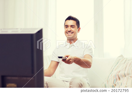 smiling man with remote control watching tv 20172795