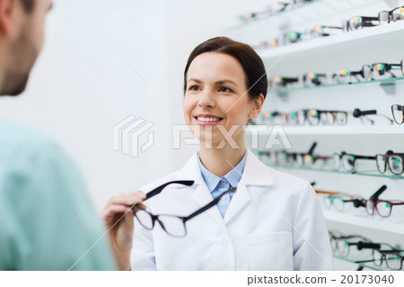 optician showing glasses to man at optics store optician showing glasses to man at optics store 20173040