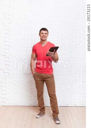 Casual Man Using Tablet Computer Over Wall Casual Man Using Tablet Computer Over Wall 20173215