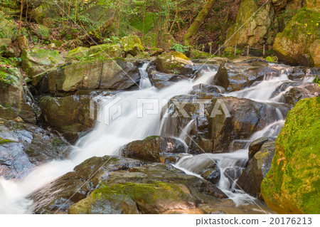 Water falls over a jumble of moss-covered boulders 20176213