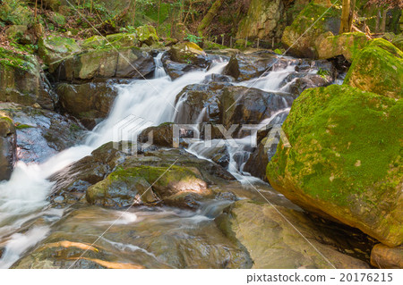 Water falls over a jumble of moss-covered boulders Water falls over a jumble of moss-covered boulders 20176215