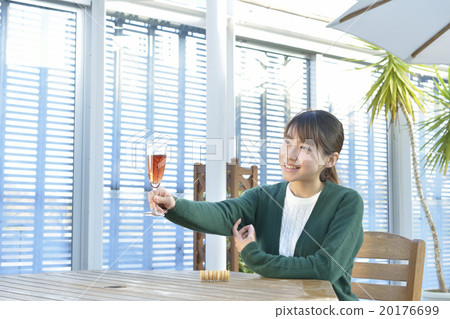 放鬆的婦女，當喝與玻璃時 20176699