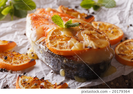 salmon steak baked with oranges macro on paper 20179364