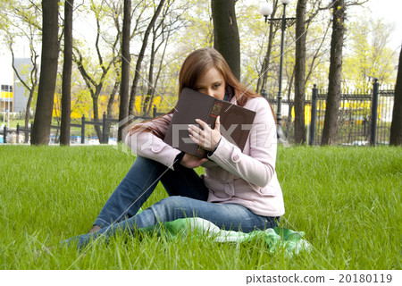 Beautiful redhead woman with book in park Beautiful redhead woman with book in park 20180119
