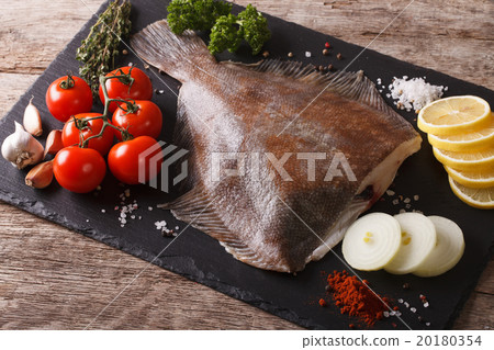 Fresh raw plaice with ingredients on a slate board Fresh raw plaice with ingredients on a slate board 20180354