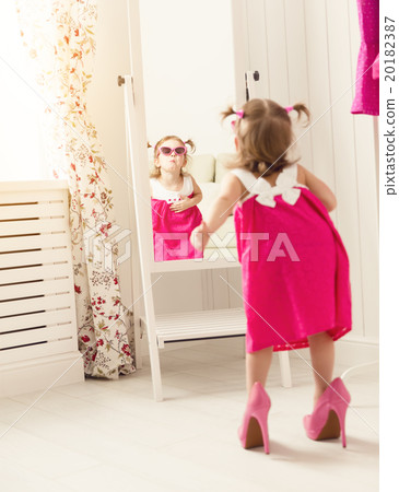 little girl child fashionista looking in the mirror at home 20182387