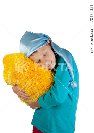 Boy in pajamas holding pillow isolated on white Boy in pajamas holding pillow isolated on white 20183331