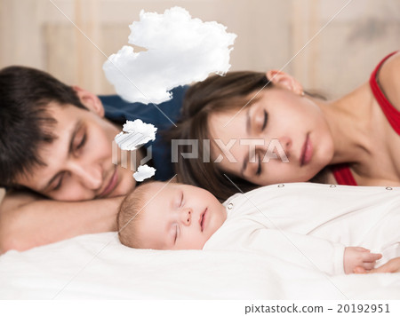 Baby sleeps  with tired parents 20192951