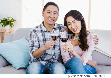 Happy young couple holding wineglasses Happy young couple holding wineglasses 20197000