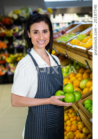 Portrait of a smiling worker taking a fruits 20197546