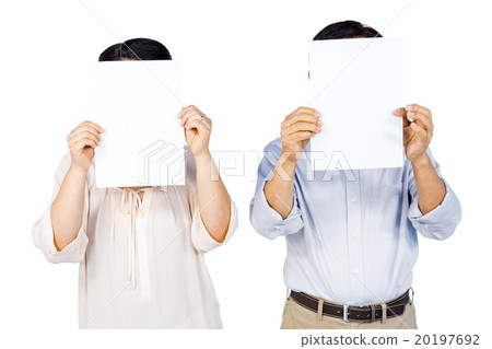 Couple holding pages over faces 20197692