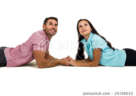 Couple laying on the floor face to face holding hands and looking up Couple laying on the floor face to face holding hands and looking up 20198018