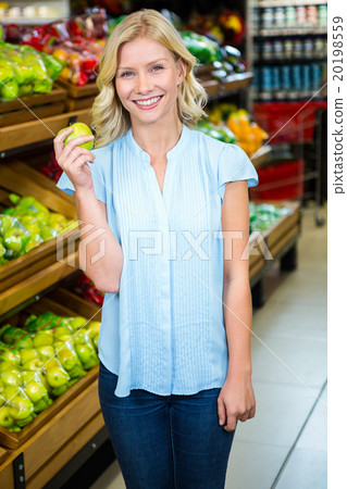 Smiling woman holding green apple 20198559
