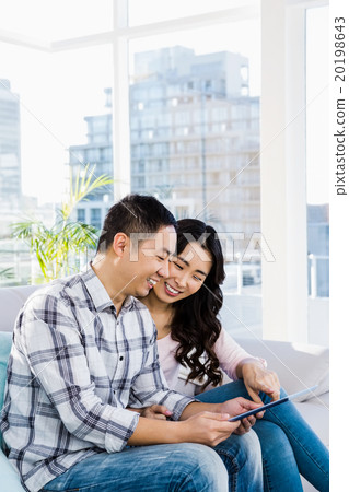 Young happy couple looking at digital tablet  20198643