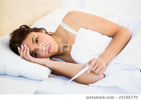 Woman holding her head and a thermometer Woman holding her head and a thermometer 20198770