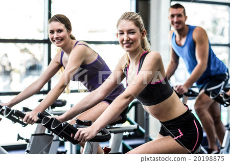 Fit people working out at spinning class 20198875