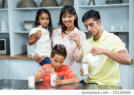 Happy family eating biscuits and drinking milk Happy family eating biscuits and drinking milk 20198896